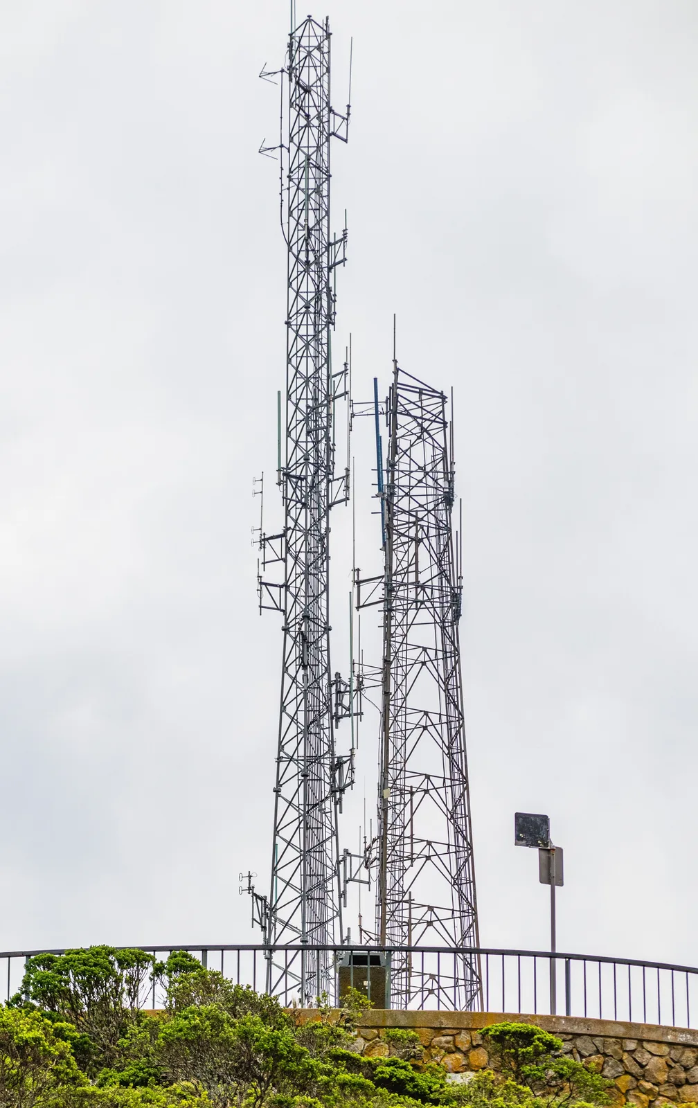 Steel lattice radio towers rising against a cloudy sky.